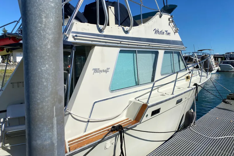 Slide: The Image of 1984 Tollycraft 34 Convertible Sedan docked at marina under clear blue sky. - 56