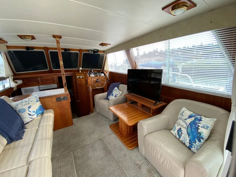 Slide: The Image of 1984 Tollycraft 34 Convertible Sedan interior with seating, TV, and helm station. - 6