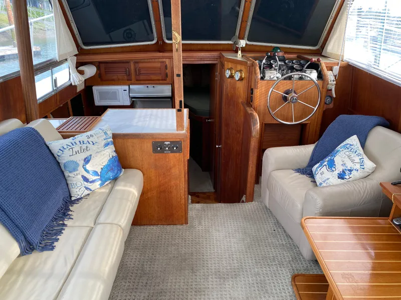 Slide: The Image of 1984 Tollycraft 34 Convertible Sedan interior with helm, seating, and nautical decor. - 7