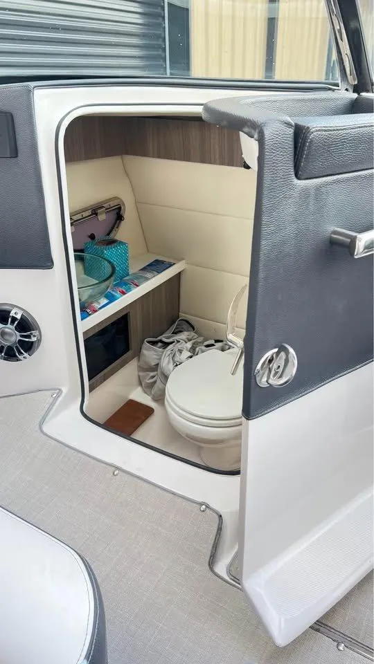 Slide: The Image of 2022 Regal 29 OBX boat interior with compact bathroom and storage shelves. - 12