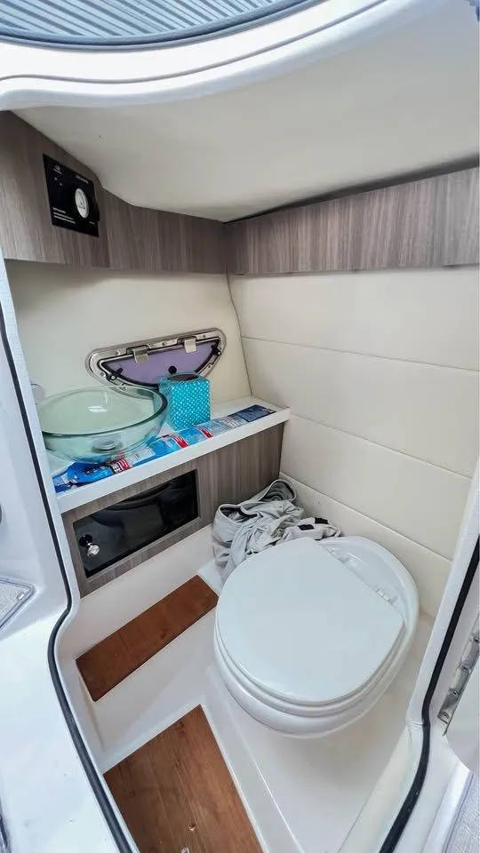 Slide: The Image of 2022 Regal 29 OBX boat bathroom with modern fixtures and wooden accents. - 13