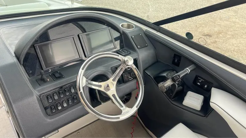 Slide: The Image of 2022 Regal 29 OBX boat dashboard with dual screens and steering wheel. - 18