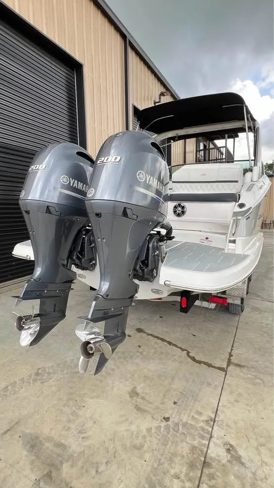 Slide: The Image of 2022 Regal 29 OBX boat with twin Yamaha 200 engines, docked outside a warehouse. - 7