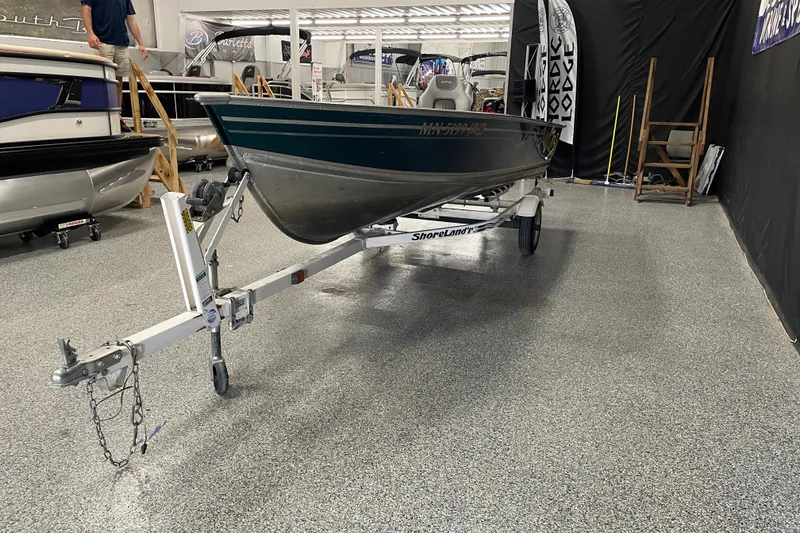 Slide: The Image of 2003 Lund 1650-V Rebel Tiller boat on trailer in showroom. - 1
