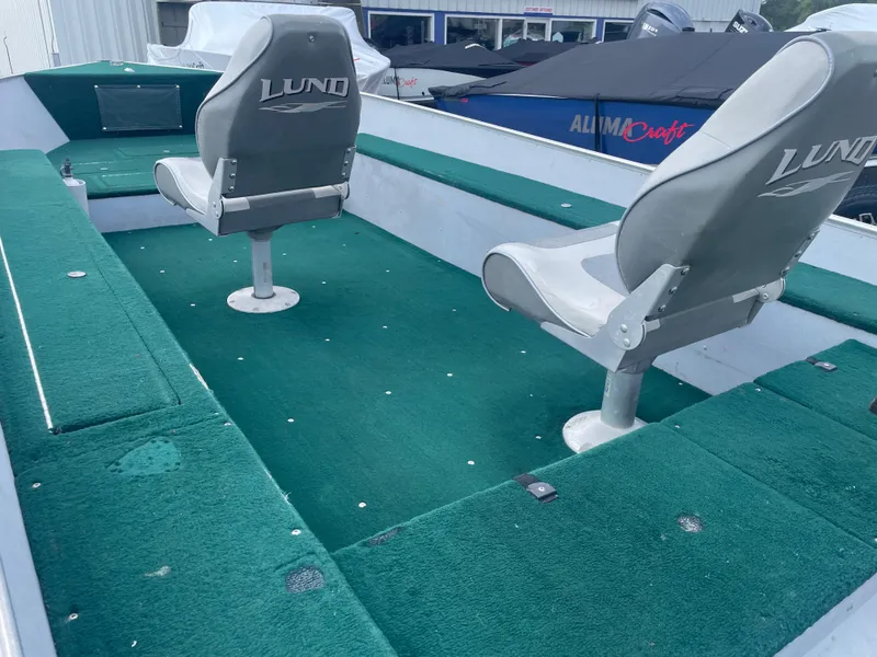Slide: The Image of 2003 Lund 1650-V Rebel Tiller boat interior with green carpet and two seats. - 16
