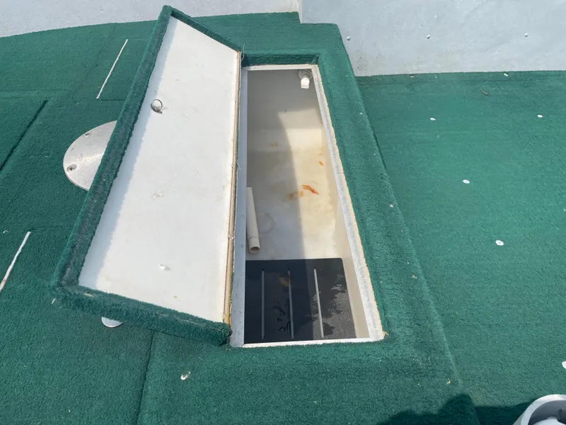 Slide: The Image of Open storage compartment on 2003 Lund 1650-V Rebel Tiller boat with green carpet. - 5