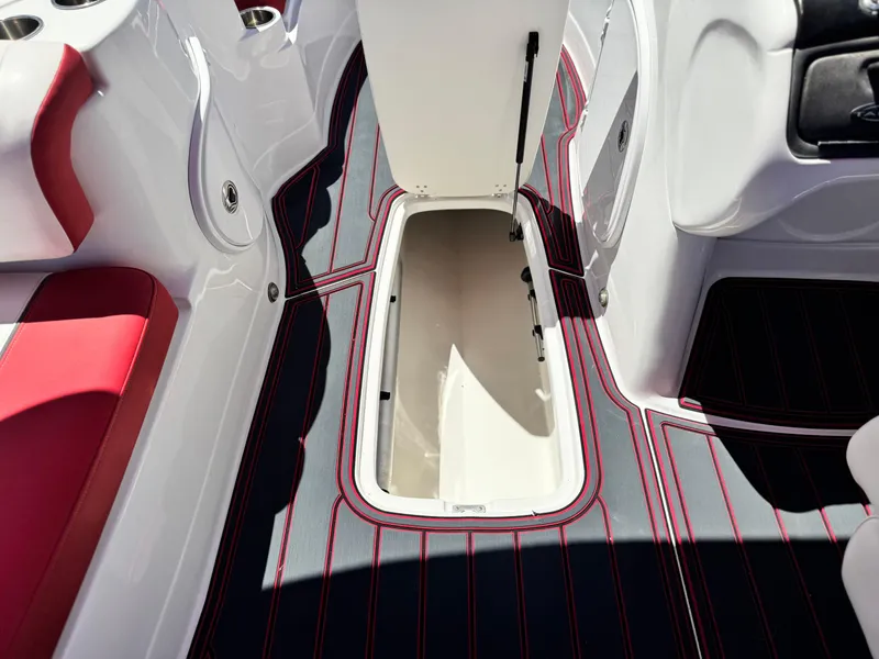 Slide: The Image of 2018 Tracker TAHOE 215 XI boat interior with open storage compartment and red-accented seating. - 26