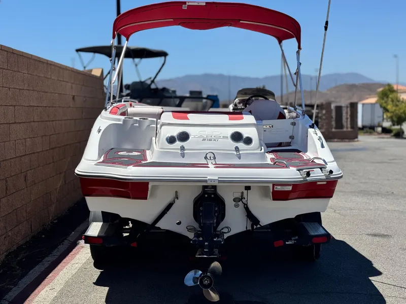 Slide: The Image of 2018 Tracker TAHOE 215 XI boat with red canopy, parked outdoors. - 3