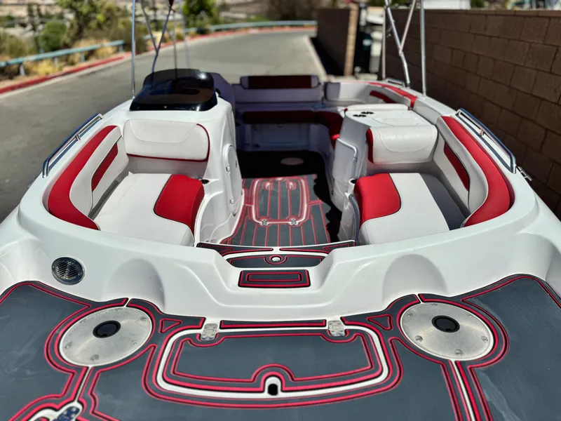 Slide: The Image of 2018 Tracker TAHOE 215 XI boat interior with red and white seating, docked outdoors. - 8