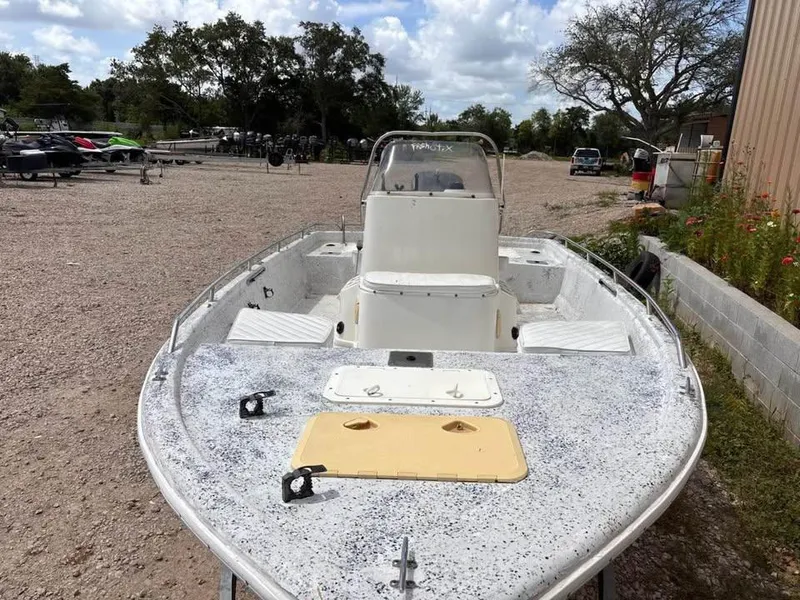 Slide: The Image of 2000 Bay Stealth 1880 Liner boat on gravel lot, surrounded by trees and trailers. - 4