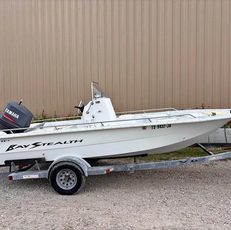Slide: The Image of Bay Stealth 1880 Liner 2000 boat on trailer with Yamaha motor, parked outdoors. - 6