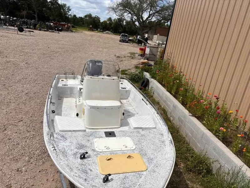 Slide: The Image of 2000 Bay Stealth 1880 Liner boat parked outdoors near a building with flowers. - 9