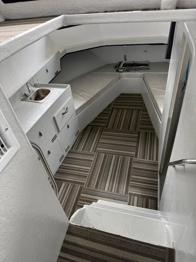 Slide: The Image of Interior of a 2004 Jefferson Lafitte boat with striped flooring and compact kitchenette. - 10