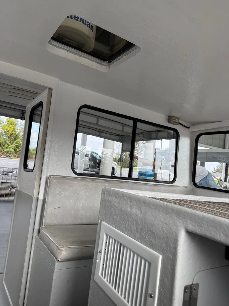Slide: The Image of Interior of a 2004 Jefferson Lafitte boat, featuring seating and windows. - 12
