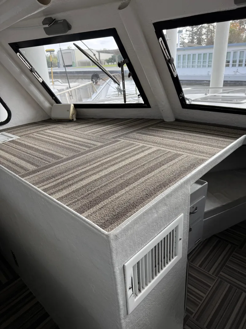 Slide: The Image of Interior of a 2004 Jefferson Lafitte boat with striped carpet and windows. - 13