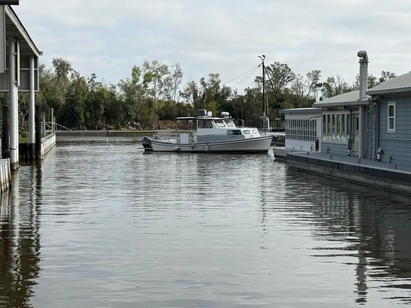 Slide: The Image of Boat on calm water near docks, surrounded by trees and buildings, Jefferson Lafitte 2004 model. - 14