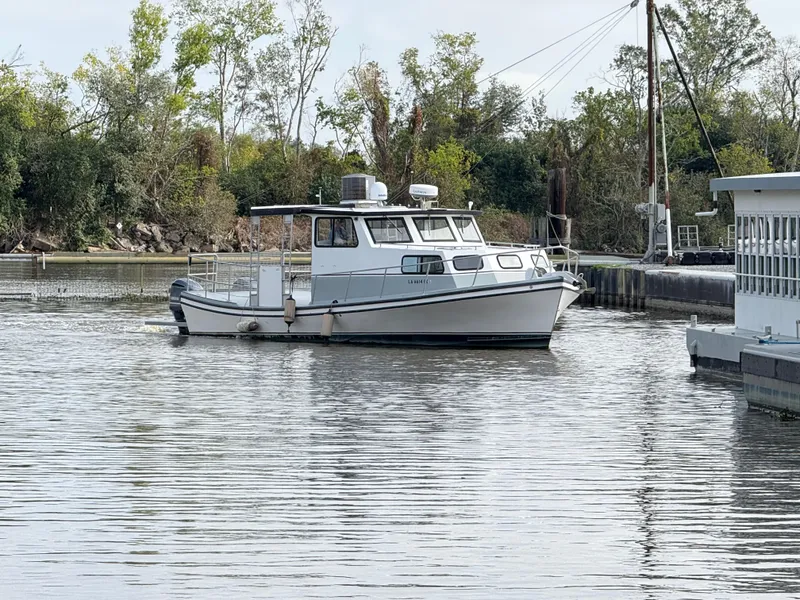 Slide: The Image of 2004 Jefferson Lafitte boat navigating a calm waterway surrounded by trees. - 3