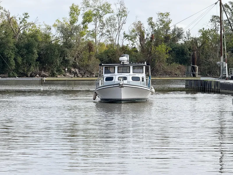 Slide: The Image of 2004 Jefferson Lafitte boat on calm water near a wooded shoreline. - 4