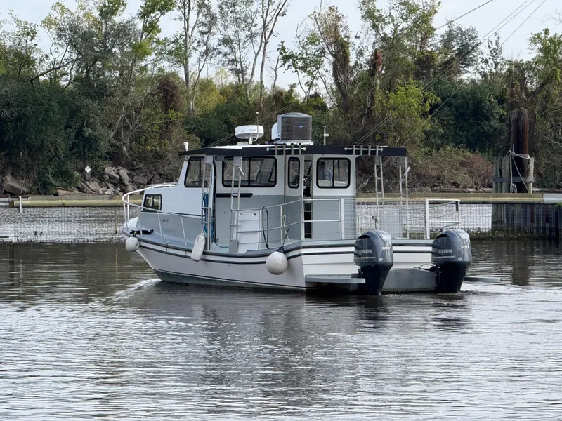 Slide: The Image of 2004 Jefferson Lafitte boat with dual Yamaha engines on a calm river. - 5