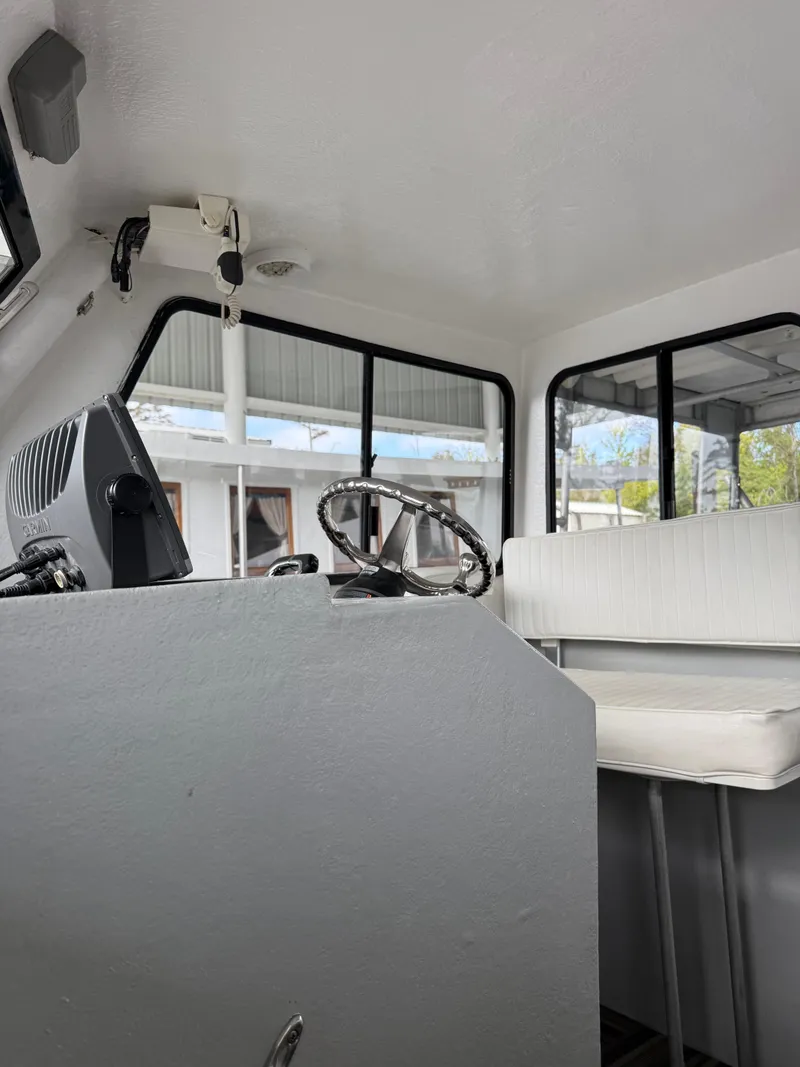 Slide: The Image of Interior of a 2004 Jefferson Lafitte boat showing steering wheel and seating area. - 6