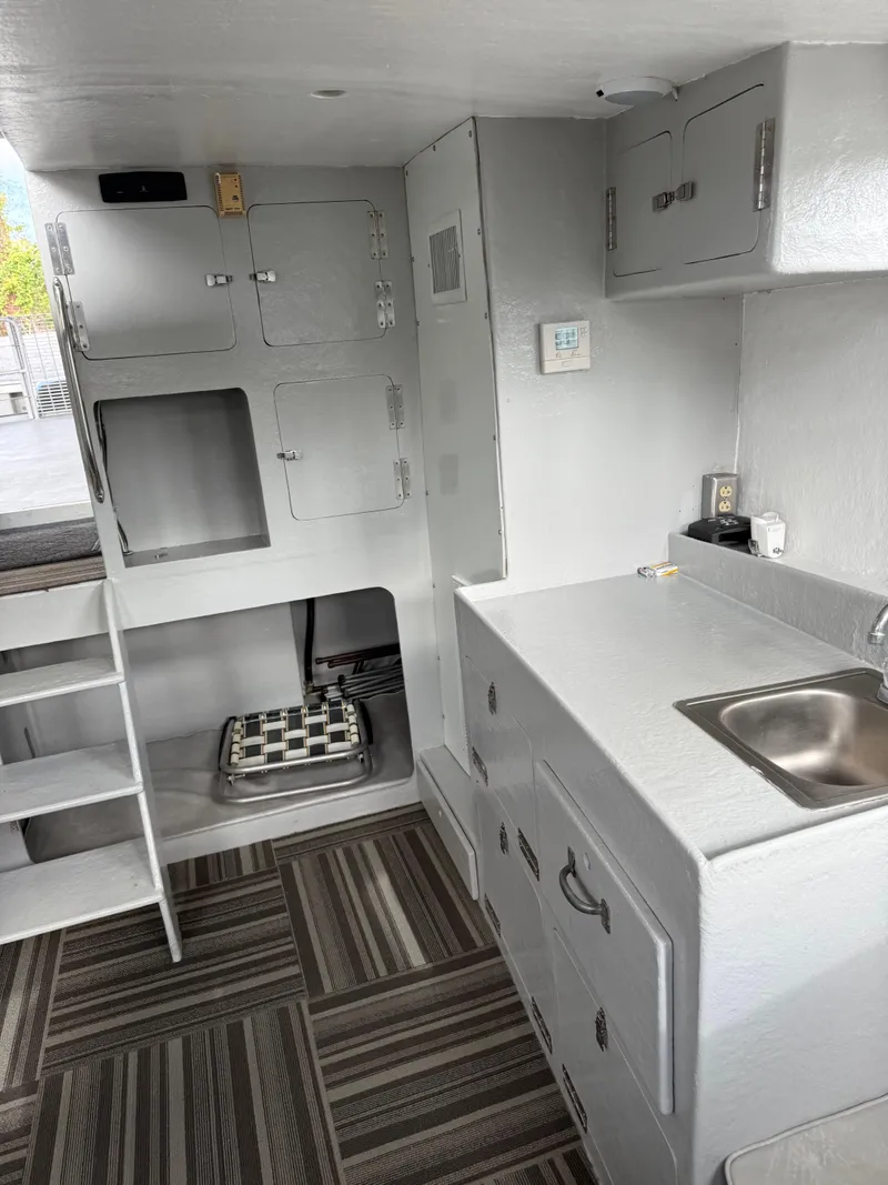 Slide: The Image of Compact interior of a 2004 Jefferson Lafitte boat with kitchenette and storage cabinets. - 7