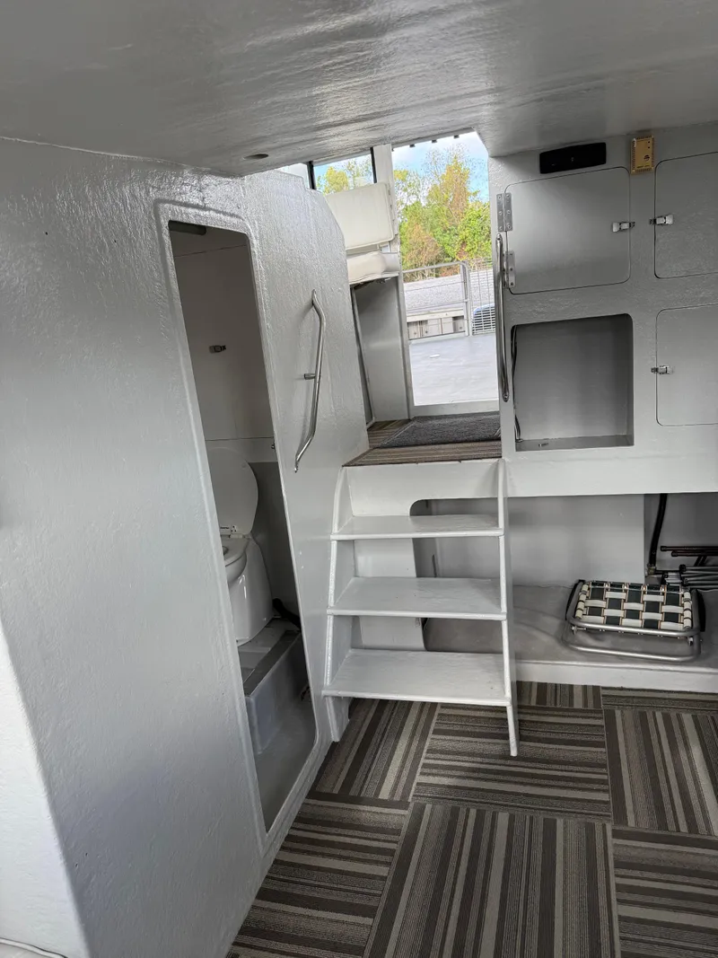 Slide: The Image of Interior of a 2004 Jefferson Lafitte boat with stairs, cabinets, and a compact bathroom. - 8