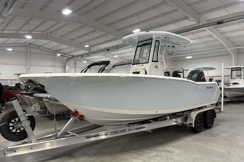 The Image of 2026 Tidewater 232 CC Adventure boat on trailer in indoor showroom. - 0