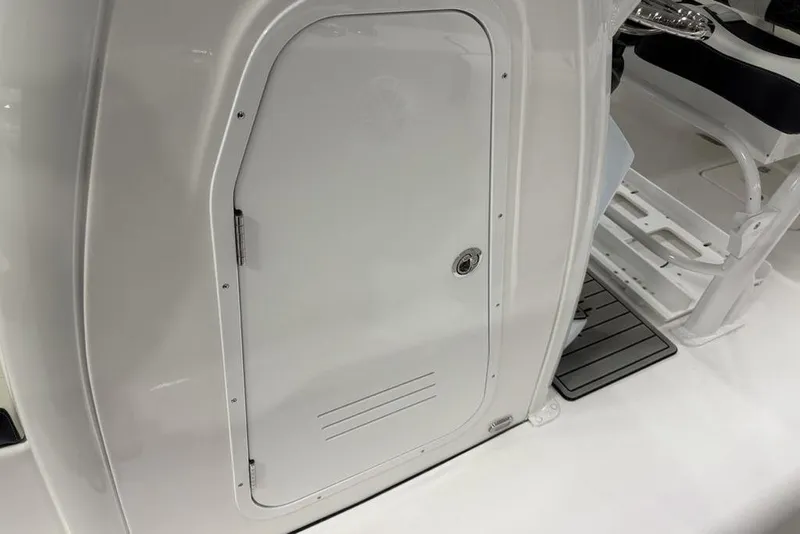 Slide: The Image of 2026 Tidewater 232 CC Adventure boat interior, featuring a sleek white storage compartment. - 11