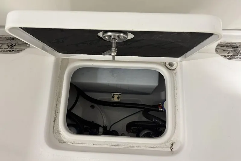 Slide: The Image of Open hatch on 2026 Tidewater 232 CC Adventure boat, revealing internal wiring and components. - 17