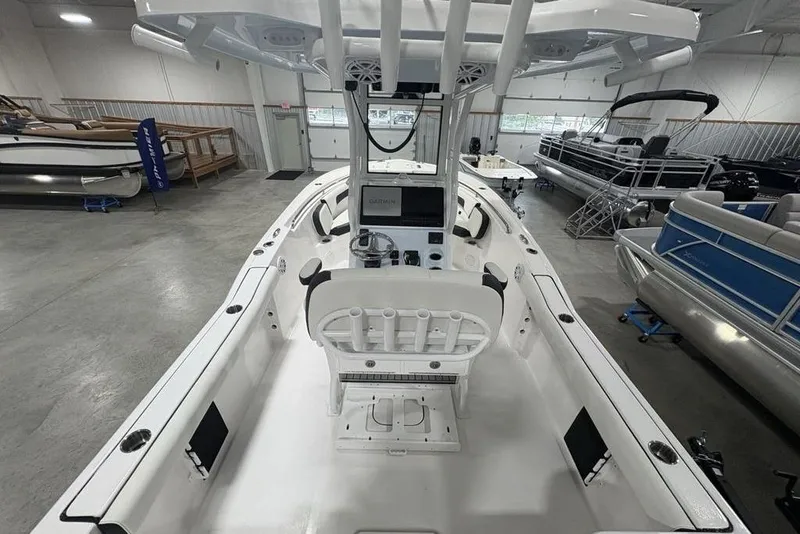 Slide: The Image of 2026 Tidewater 232 CC Adventure boat interior in showroom, featuring helm and seating. - 22