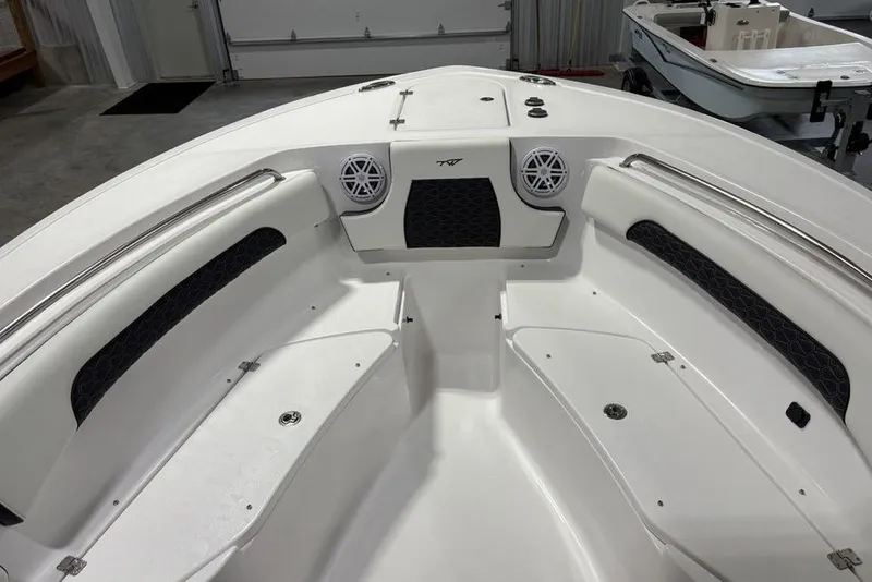 Slide: The Image of 2026 Tidewater 232 CC Adventure boat interior with seating and speakers in a garage. - 6