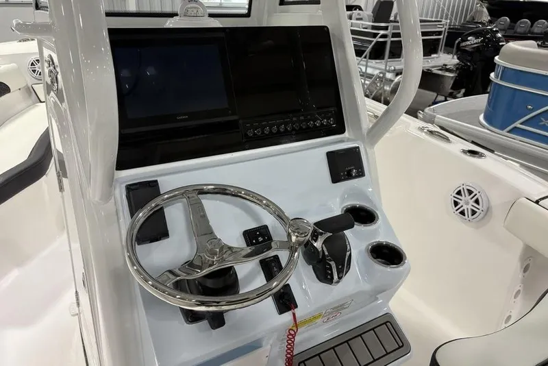 Slide: The Image of 2026 Tidewater 232 CC Adventure boat console with steering wheel and controls. - 9