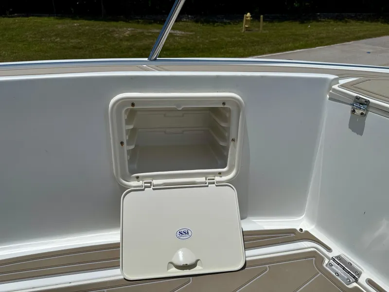 Slide: The Image of 2016 Key Largo 2100 WI CC boat storage compartment with open hatch and speaker. - 21