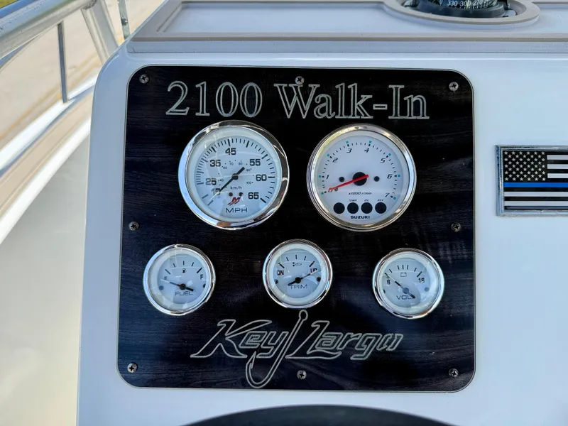 Slide: The Image of Dashboard of 2016 Key Largo 2100 WI CC boat with gauges and American flag decal. - 14