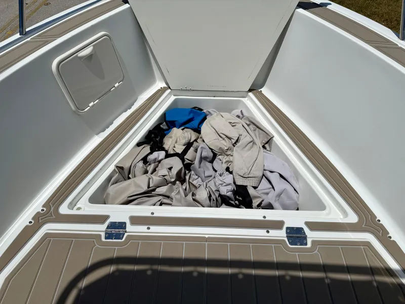 Slide: The Image of Open storage compartment on 2016 Key Largo 2100 WI CC boat with assorted items inside. - 22