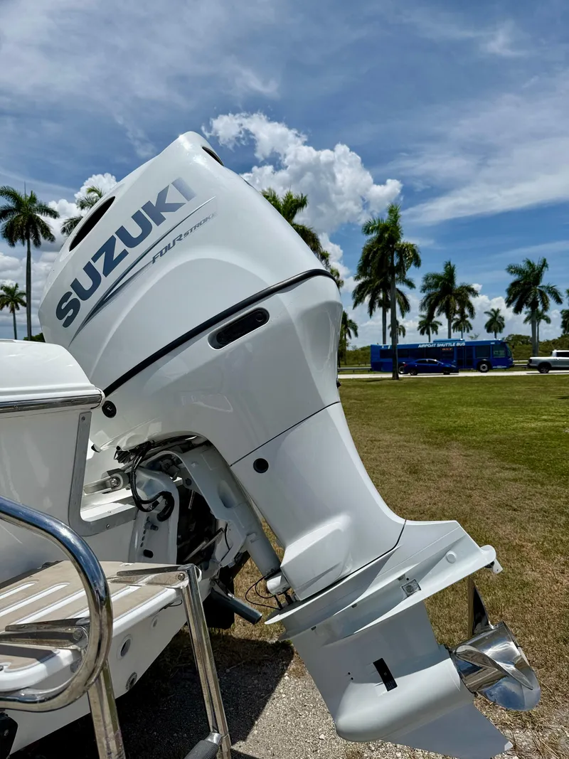 Slide: The Image of 2016 Key Largo 2100 WI CC boat with Suzuki outboard motor, palm trees in background. - 33
