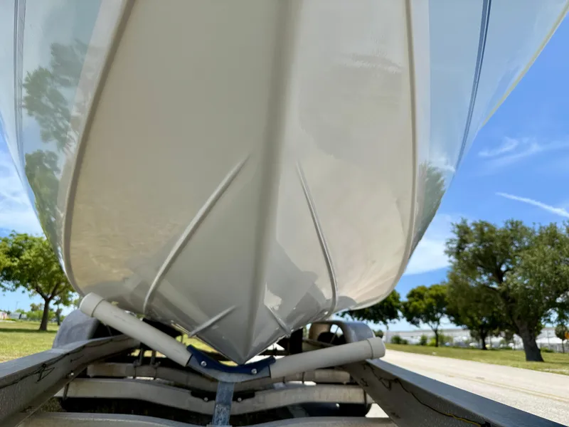 Slide: The Image of 2016 Key Largo 2100 WI CC boat hull on trailer, sunny day, trees in background. - 38