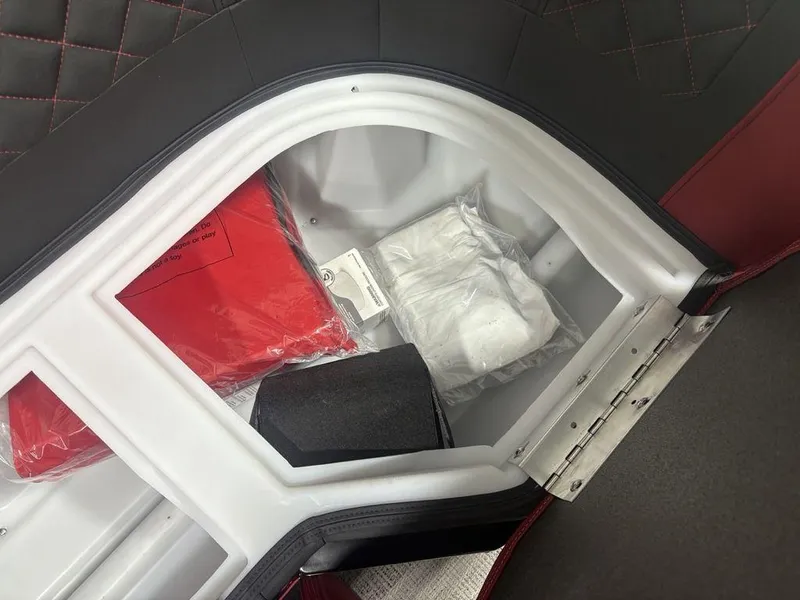Slide: The Image of Storage compartment in 2025 Godfrey AquaPatio 235 DFLC boat, featuring life jackets and accessories. - 14