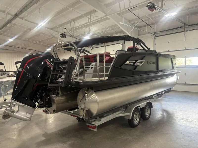Slide: The Image of 2025 Godfrey AquaPatio 235 DFLC pontoon boat on trailer in indoor showroom. - 2