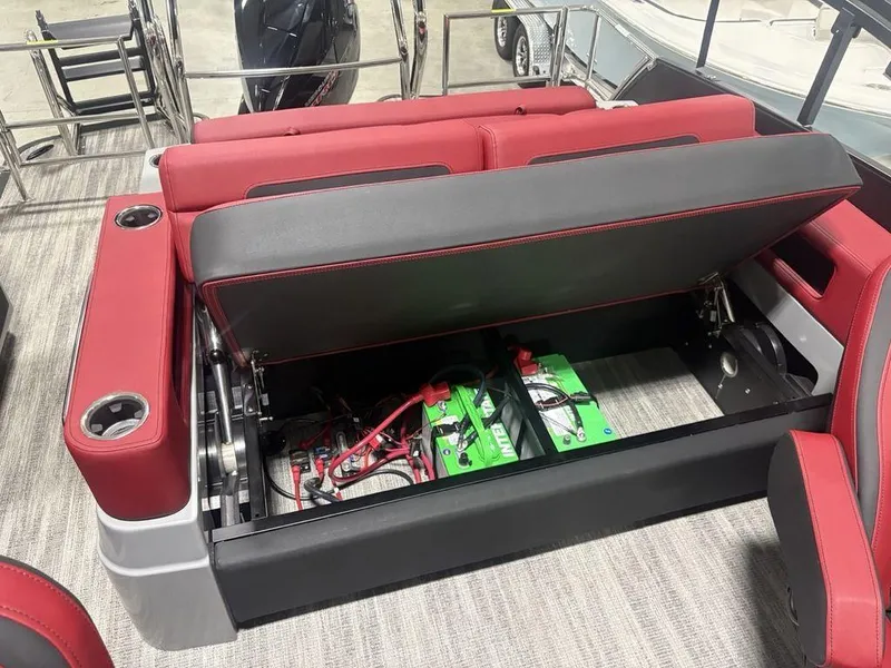 Slide: The Image of 2025 Godfrey AquaPatio 235 DFLC boat seat storage with batteries and red upholstery. - 25