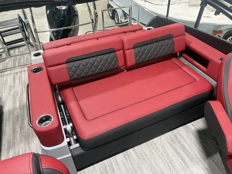 Slide: The Image of Red and black seating on 2025 Godfrey AquaPatio 235 DFLC boat, featuring cup holders. - 26