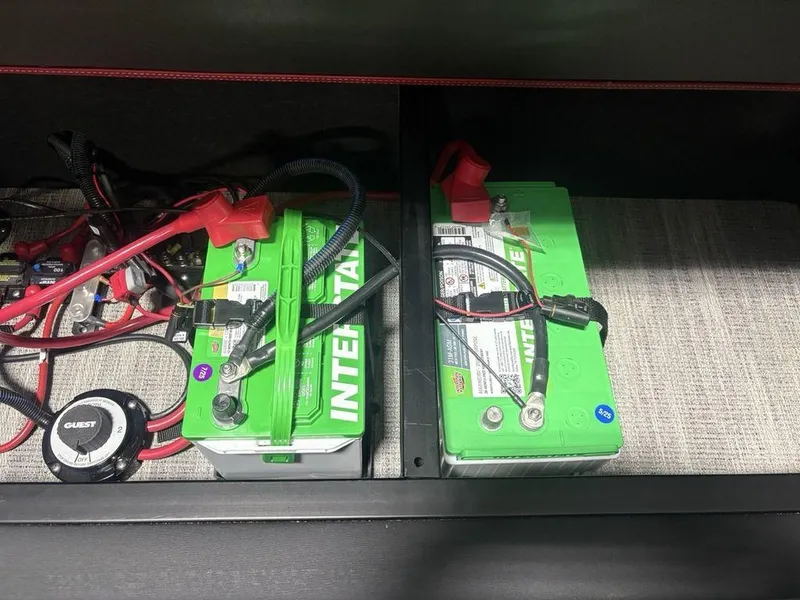 Slide: The Image of Two green Interstate batteries with wiring in a 2025 Godfrey AquaPatio 235 DFLC iMPACT boat. - 27