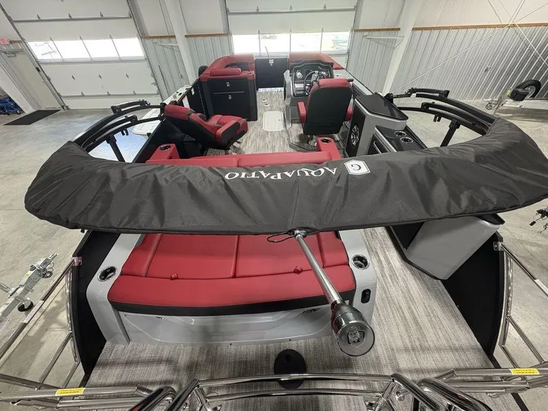 Slide: The Image of 2025 Godfrey AquaPatio 235 DFLC iMPACT pontoon boat with red seating in a showroom. - 33