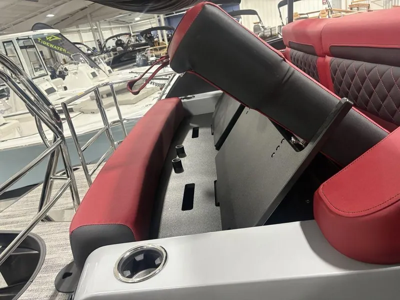 Slide: The Image of 2025 Godfrey AquaPatio 235 DFLC boat interior with red and black seating, showroom display. - 35