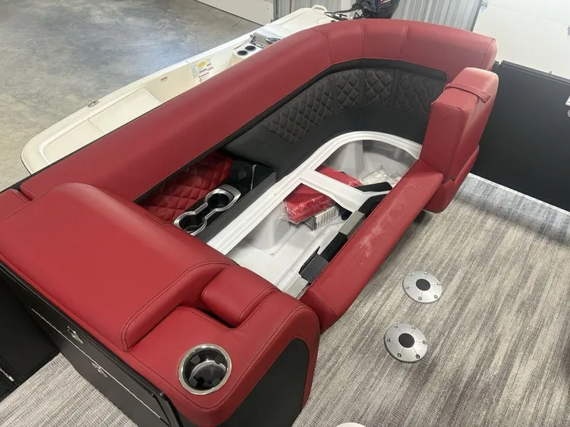 Slide: The Image of Luxurious red seating on 2025 Godfrey AquaPatio 235 DFLC boat, featuring cup holders and storage. - 8