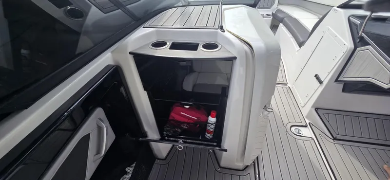 Slide: The Image of 2023 Yamaha Boats 252SD interior storage compartment with cup holders and accessories. - 11