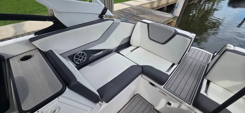 Slide: The Image of 2023 Yamaha Boats 252SD interior with sleek seating and modern design by the water. - 12