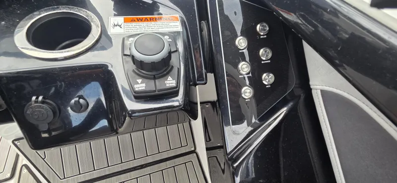 Slide: The Image of Control panel of 2023 Yamaha Boats 252SD with switches and cup holder. - 18
