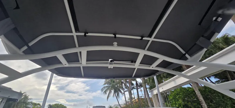 Slide: The Image of 2023 Yamaha Boats 252SD canopy with tropical background and palm trees. - 23