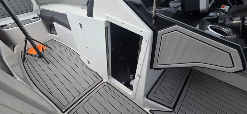 Slide: The Image of 2023 Yamaha Boats 252SD interior with open storage compartment and sleek flooring. - 25